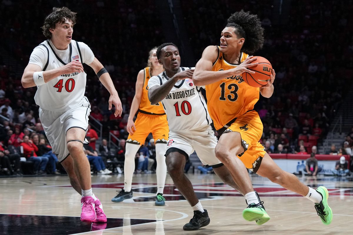 Wyoming guard Adam Harakow (13) dribbles the ball past defenders during an NCAA basketball game against SDSU, Tuesday February 03, 2026 in San Diego, California. Wyoming guard Adam Harakow (13) dribbles the ball past defenders during an NCAA basketball game against SDSU, Tuesday February 03, 2026 in San Diego, California.