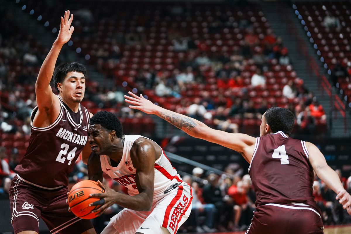UNLV forward Kimani Hamilton (2) takes the ball through Montana Kenyon Aguino (24) and guard Tyler Thompson (4) during first half of college basketball game against Montana on Tuesday, Nov. 11, 2025 at Thomas and Mack Center in Las Vegas. UNLV forward Kimani Hamilton (2) takes the ball through Montana Kenyon Aguino (24) and guard Tyler Thompson (4) during first half of college basketball game against Montana on Tuesday, Nov. 11, 2025 at Thomas and Mack Center in Las Vegas.