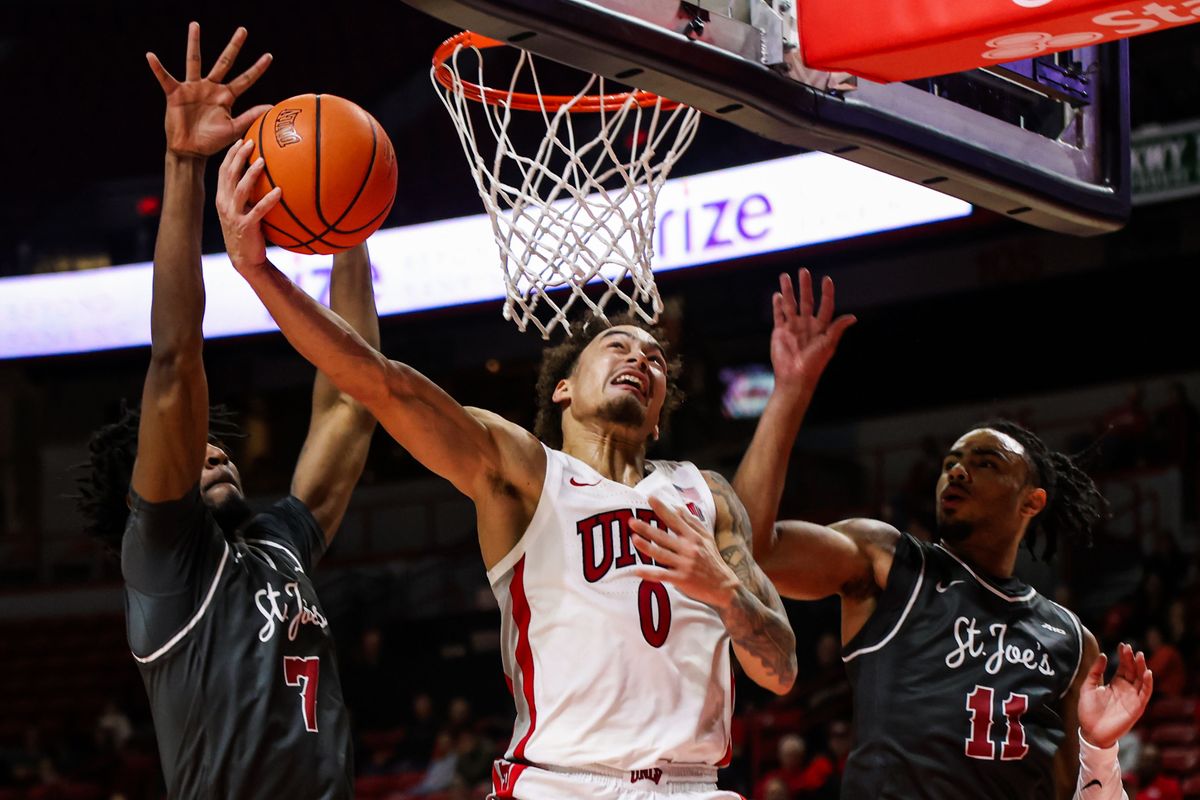 UNLV Runnin' Rebels G Dravyn Gibbs-Lawhorn (0) attempts a layup shot past two Saint Joseph's Hawks players during an NCAA basketball game against the Saint Joseph's Hawks on Thursday November 20, 2025, in Las Vegas, Nevada. UNLV Runnin' Rebels G Dravyn Gibbs-Lawhorn (0) attempts a layup shot past two Saint Joseph's Hawks players during an NCAA basketball game against the Saint Joseph's Hawks on Thursday November 20, 2025, in Las Vegas, Nevada.