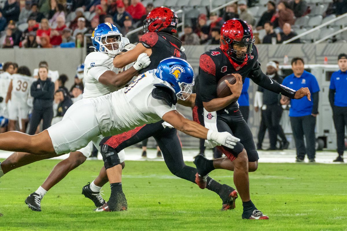 San Diego State quarterback Jayden Denegal (4) is tackled while running during an NCAA Football game between San Jose State and San Diego State, Saturday November 22, 2025 in San Diego, Calif. San Diego State quarterback Jayden Denegal (4) is tackled while running during an NCAA Football game between San Jose State and San Diego State, Saturday November 22, 2025 in San Diego, Calif.