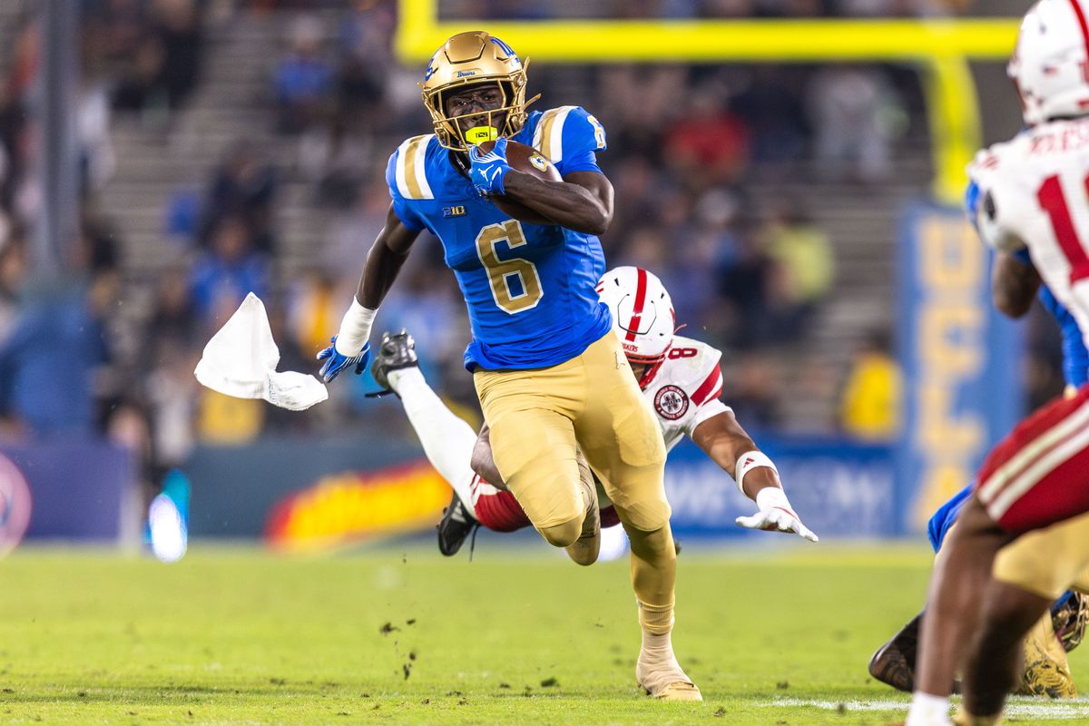 UCLA Bruins running back Anthony Woods (6) runs the ball while getting jumped on from behind as towel flys out of back pocket during the game against Nebraska Cornhuskers at Rose Bowl Stadium on November 8, 2025 in Pasadena, California. UCLA Bruins running back Anthony Woods (6) runs the ball while getting jumped on from behind as towel flys out of back pocket during the game against Nebraska Cornhuskers at Rose Bowl Stadium on November 8, 2025 in Pasadena, California.