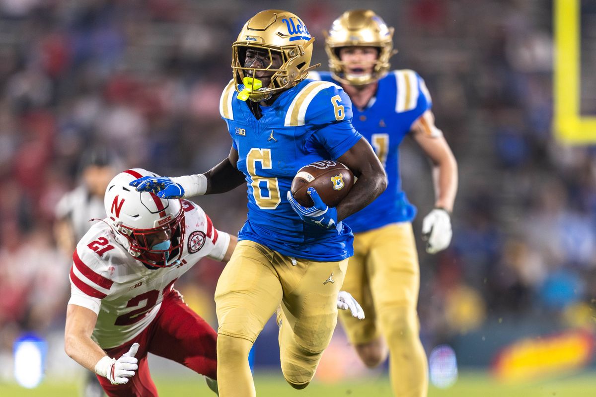 UCLA Bruins running back Anthony Woods (6) runs the ball while shoving Nebraska Cornhuskers defensive back Rex Guthrie (21) during the game against Nebraska Cornhuskers at Rose Bowl Stadium on November 8, 2025 in Pasadena, California. UCLA Bruins running back Anthony Woods (6) runs the ball while shoving Nebraska Cornhuskers defensive back Rex Guthrie (21) during the game against Nebraska Cornhuskers at Rose Bowl Stadium on November 8, 2025 in Pasadena, California.