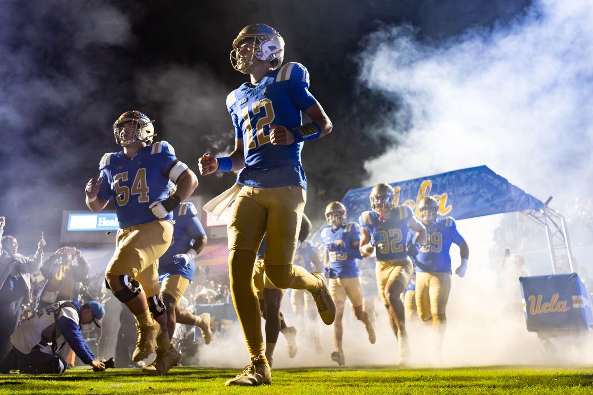 UCLA Bruins quarterback Luke Duncan (12) runs out of the smoke before the game against Washington Huskies at Rose Bowl Stadium on November 22, 2025 in Pasadena, California. UCLA Bruins quarterback Luke Duncan (12) runs out of the smoke before the game against Washington Huskies at Rose Bowl Stadium on November 22, 2025 in Pasadena, California.