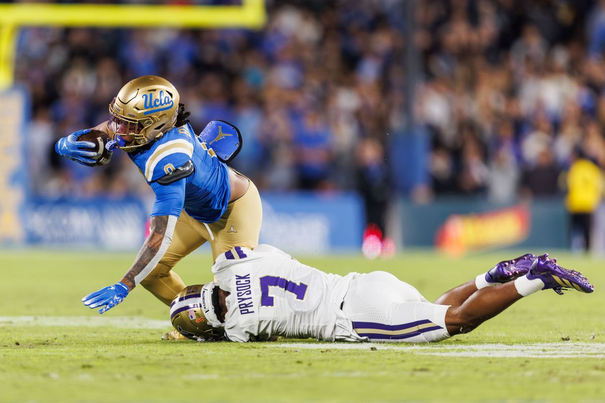 UCLA Bruins running back Jalen Berger (0) gets tackled by Washington Huskies cornerback Ephesians Prysock (7) during the game against Washington Huskies at Rose Bowl Stadium on November 22, 2025 in Pasadena, California. UCLA Bruins running back Jalen Berger (0) gets tackled by Washington Huskies cornerback Ephesians Prysock (7) during the game against Washington Huskies at Rose Bowl Stadium on November 22, 2025 in Pasadena, California.