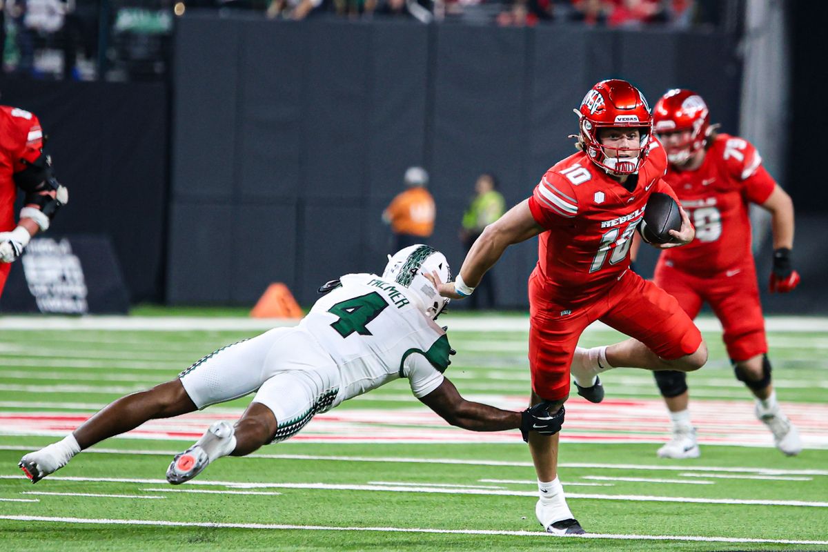 UNLV Rebels QB Anthony Colandrea (10) evades a tackle from Hawai'i Rainbow Warriors DB Elijah Palmer (4) during a college football game on Friday November 21, 2025, in Las Vegas, Nevada. UNLV Rebels QB Anthony Colandrea (10) evades a tackle from Hawai'i Rainbow Warriors DB Elijah Palmer (4) during a college football game on Friday November 21, 2025, in Las Vegas, Nevada.