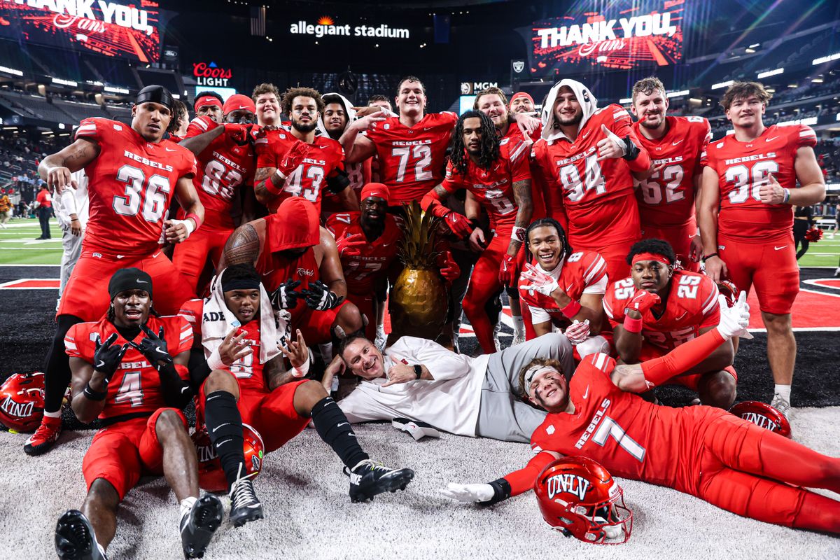 UNLV Rebels HC Dan Mullen poses with the Island Showdown Trophy with his team after defeating the Hawai'i Rainbow Warriors in the 9th Island Classic on Friday November 21, 2025, in Las Vegas, Nevada. UNLV Rebels HC Dan Mullen poses with the Island Showdown Trophy with his team after defeating the Hawai'i Rainbow Warriors in the 9th Island Classic on Friday November 21, 2025, in Las Vegas, Nevada.