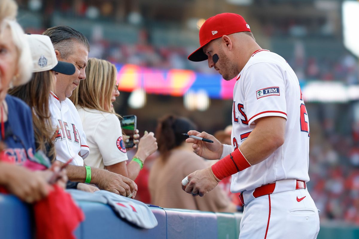 Mike Trout #27 of the Los Angeles Angels signs an autograph for a fan prior to a game against the New York Mets at Angel Stadium on May 1, 2026, in Anaheim, California. Mike Trout #27 of the Los Angeles Angels signs an autograph for a fan prior to a game against the New York Mets at Angel Stadium on May 1, 2026, in Anaheim, California.