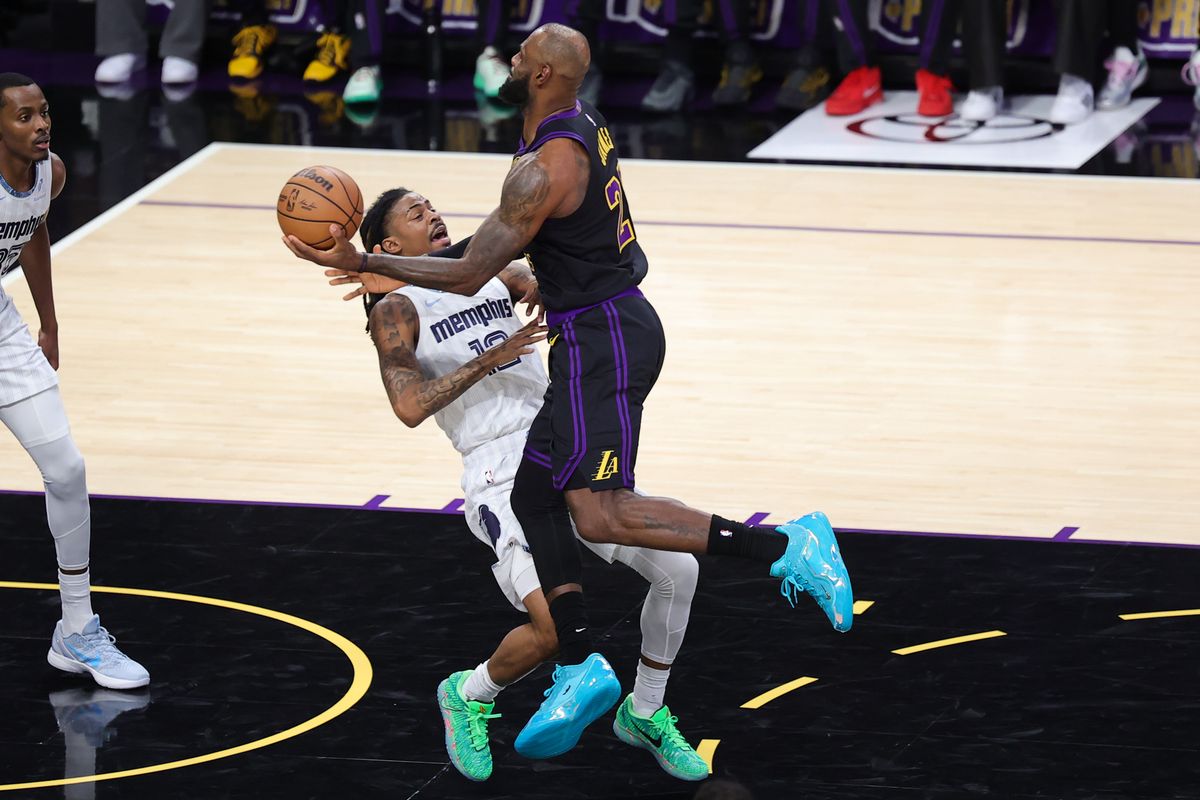 #23 SF LeBron James of the Los Angeles Lakers charges into #12 PG Ja Morant of the Memphis Grizzlies during an NBA game on January 2, 2026 in Los Angeles, CA. #23 SF LeBron James of the Los Angeles Lakers charges into #12 PG Ja Morant of the Memphis Grizzlies during an NBA game on January 2, 2026 in Los Angeles, CA.