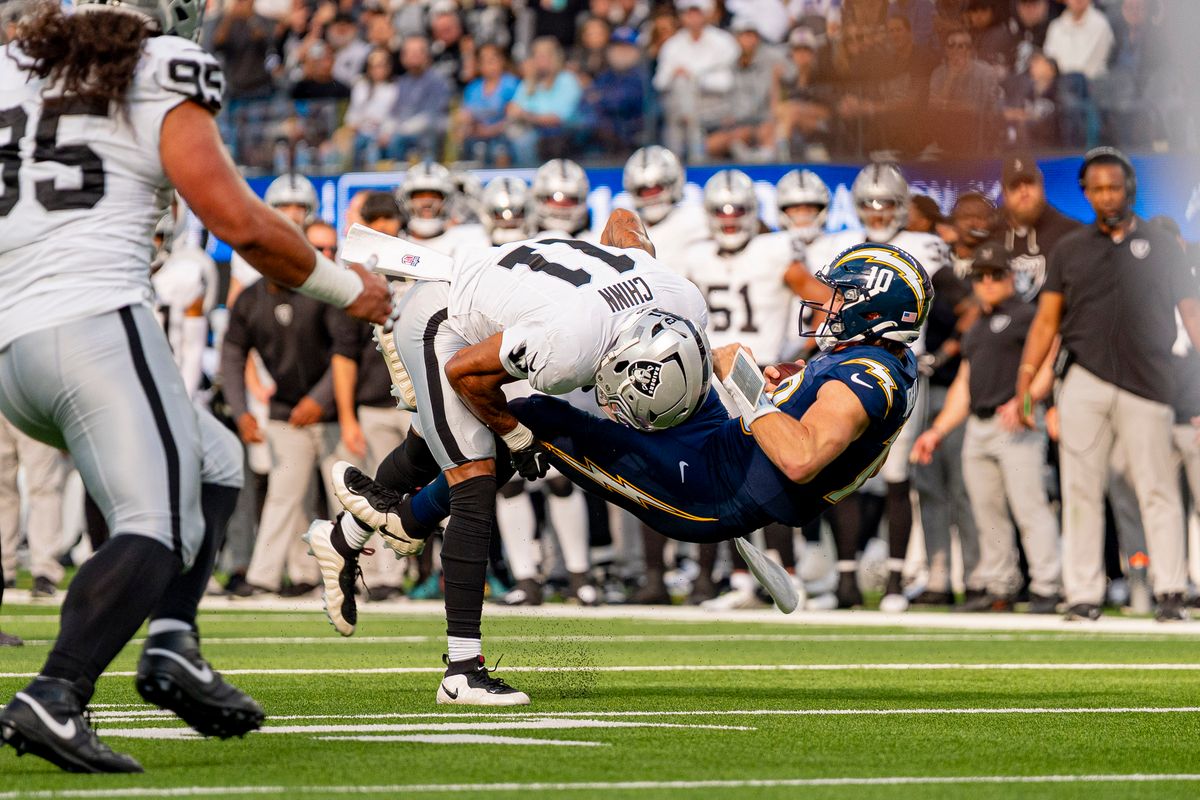 Las Vegas Raiders safety, Jeremy Chinn (11) tackles Justin Herbert (10) during an NFL football game against the Los Angeles Chargers on November 30, 2025 in Los Angeles, CA. Las Vegas Raiders safety, Jeremy Chinn (11) tackles Justin Herbert (10) during an NFL football game against the Los Angeles Chargers on November 30, 2025 in Los Angeles, CA.