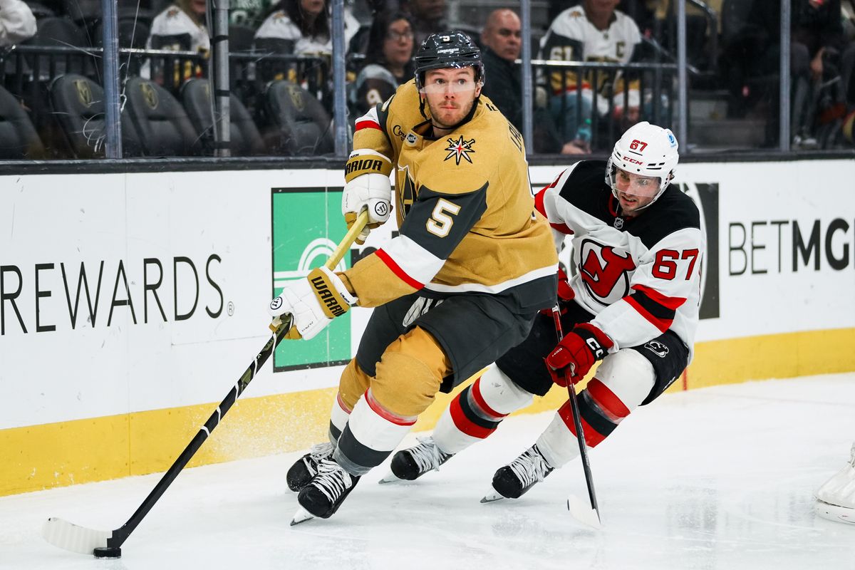 Vegas Golden Knights defensemen Jeremy Lauzon (5) skates the puck around the goal, trying to escape Devils lcenter Xavier Parent during third period of NHL game against New Jersey Devils on Wed., Dec. 17, 2025, at T-Mobile Arena in Las Vegas. Vegas Golden Knights defensemen Jeremy Lauzon (5) skates the puck around the goal, trying to escape Devils lcenter Xavier Parent during third period of NHL game against New Jersey Devils on Wed., Dec. 17, 2025, at T-Mobile Arena in Las Vegas.