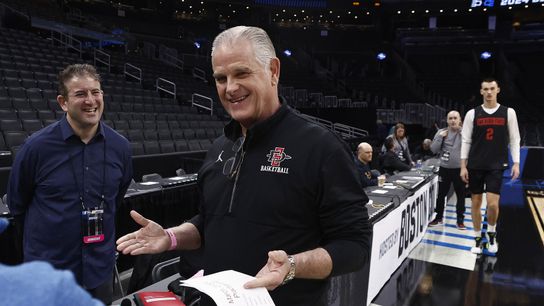 San Diego State head coach Brian Dutcher smiles as he talks with broadcasters during practice in preparation for their East semifinal game against Connecticut at TD Garden.
